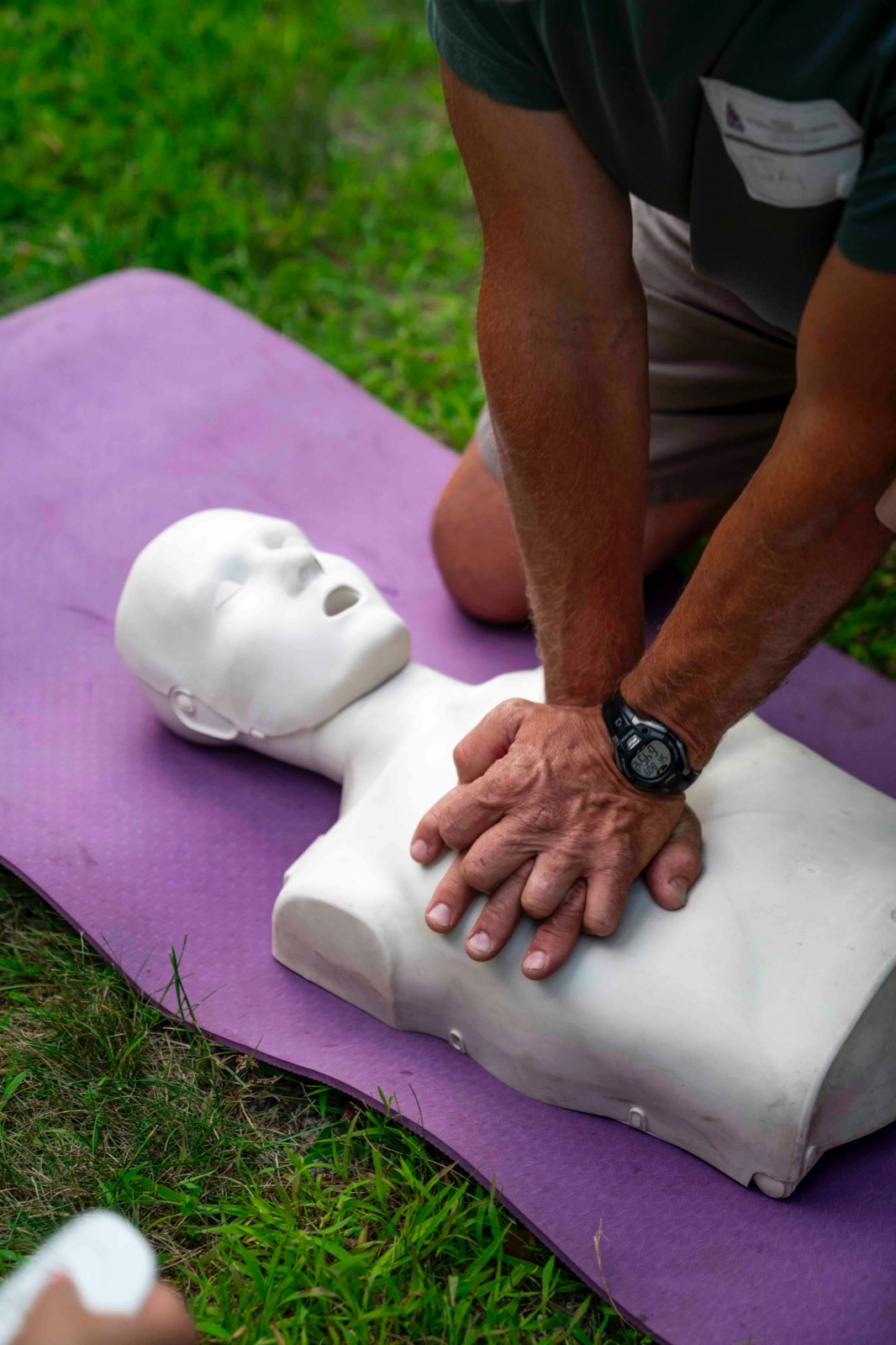 Instructor demonstrating CPR chest compressions on a training dummy